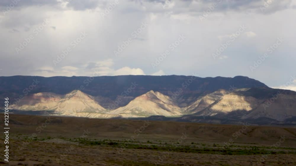 Smooth gliding shot of desert mountains with light shining through clouds Smooth gliding shot of desert mountains with light shining through clouds