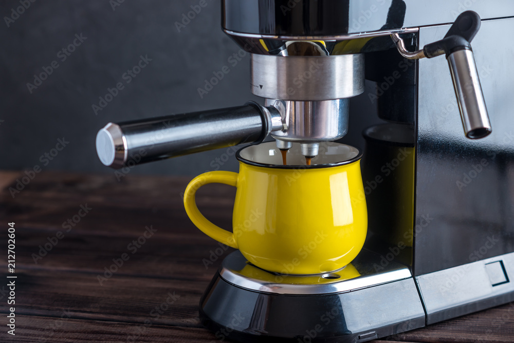 Preparation of espresso. Black coffee pouring from the machine in the Cup. Professional coffee brewing at home Preparation of espresso. Black coffee pouring from the machine in the Cup. Professional coffee brewing at home