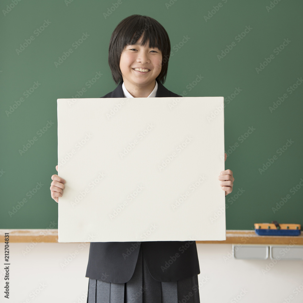 メッセージボードを持ち微笑む女子学生