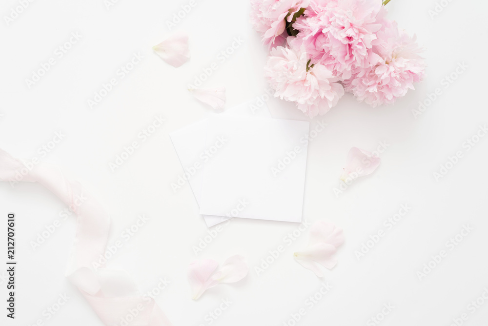 Styled feminine flat lay, white background, top view. Blank page mock up, envelope, peonies with petals, pink ribbon. Styled feminine flat lay, white background, top view. Blank page mock up, envelope, peonies with petals, pink ribbon.