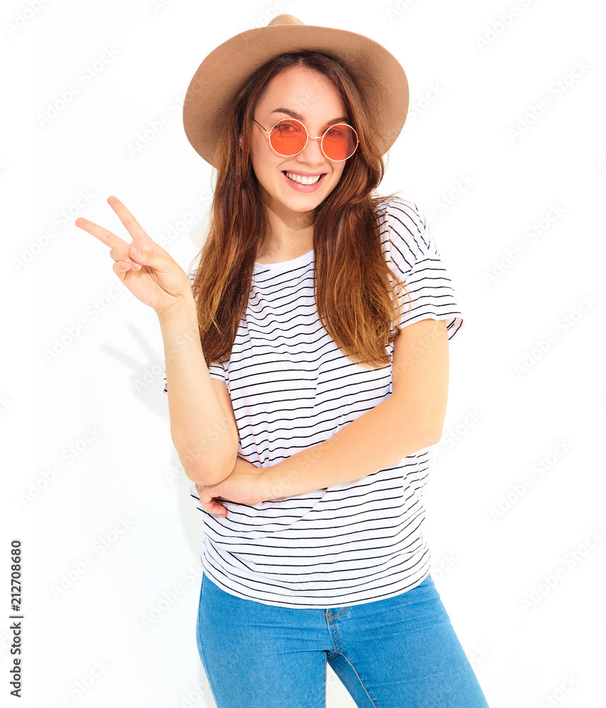 Portrait of young stylish laughing girl model in casual summer clothes in brown hat with natural makeup isolated on white background. Showing peace sign