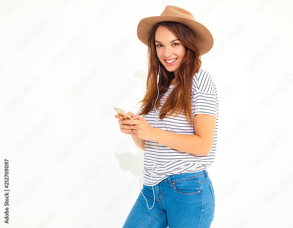 beautiful girl in casual hipster summer clothes with no makeup in brown hat listening music in smartphone with headphones isolated on white. Dancing beautiful girl in casual hipster summer clothes with no makeup in brown hat listening music in smartphone with headphones isolated on white. Dancing
