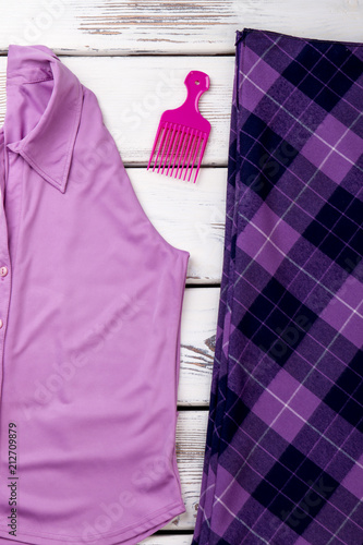 Concept of purple women's clothes and comb. White wooden desks surface background. © DenisProduction.com