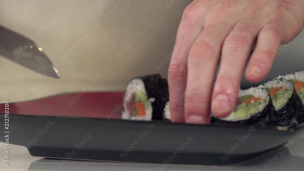 Tracking shot of sushi chef slicing fresh tuna roll with sharp japanese knife Tracking shot of sushi chef slicing fresh tuna roll with sharp japanese knife