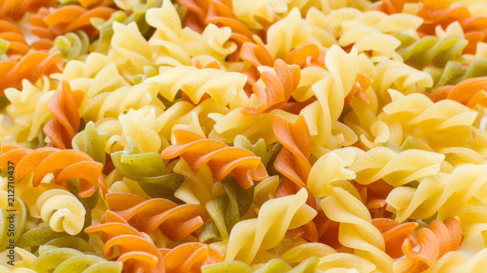 Multicolor raw pasta close-up. Top view. Kitchen food background Multicolor raw pasta close-up. Top view. Kitchen food background
