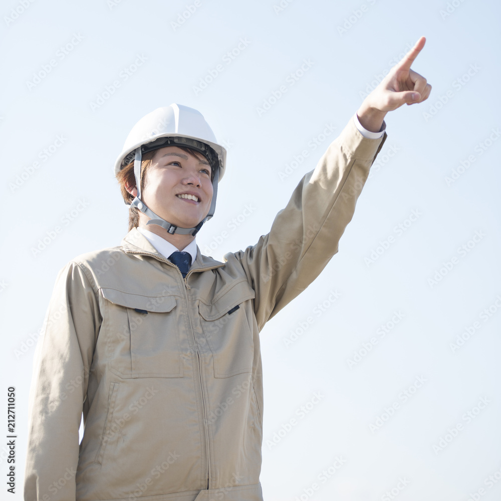 遠くを指差す作業員 遠くを指差す作業員