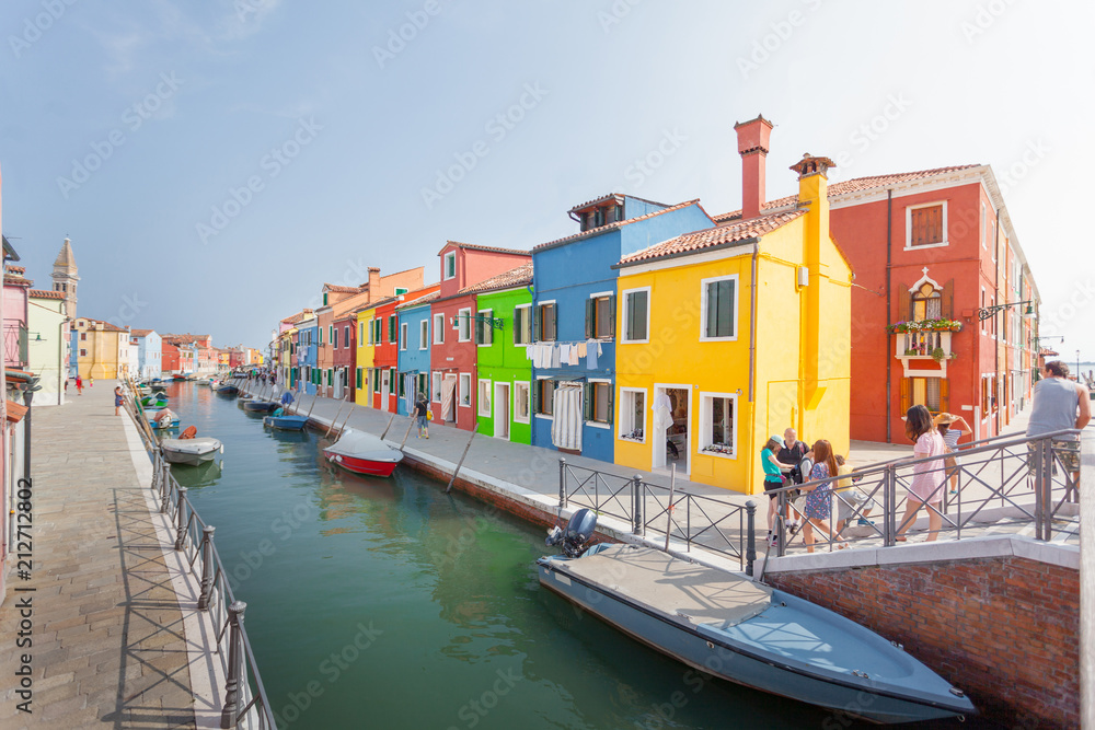 Street with colored houses on the island of Burano and with a canal in the middle, near Venice, Italy