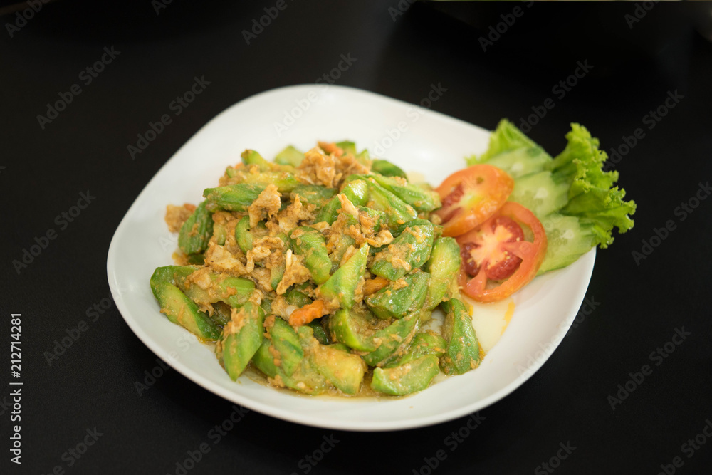 Chinese gourd menu, stir fried with eggs against a black background.