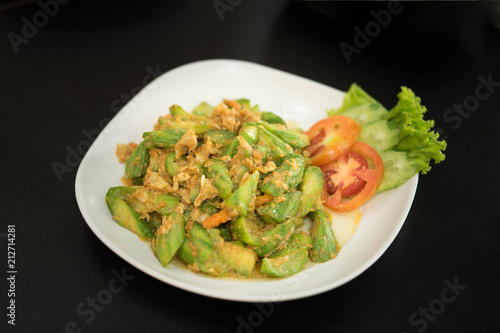 Chinese gourd menu, stir fried with eggs against a black background.