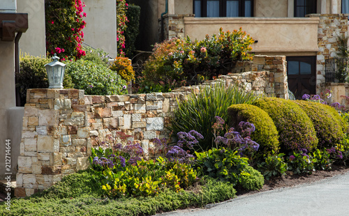 Home landscaping example with a garden wall featuring intricate stone work and a varied palette of planting