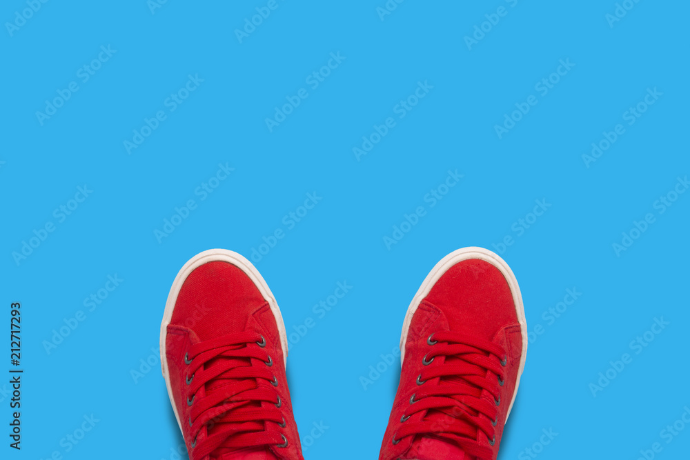 Red sneakers on a blue background. Minimalism style. Flat lay, top view