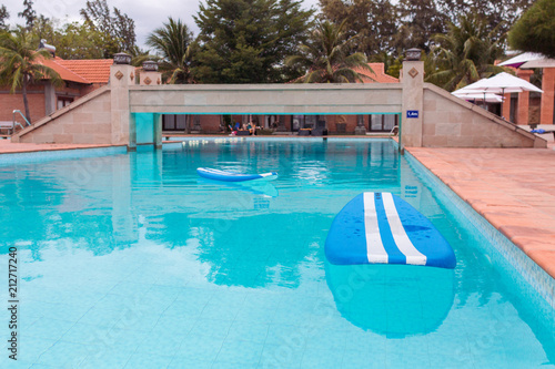 Blue surfboard floating on blue pool surface