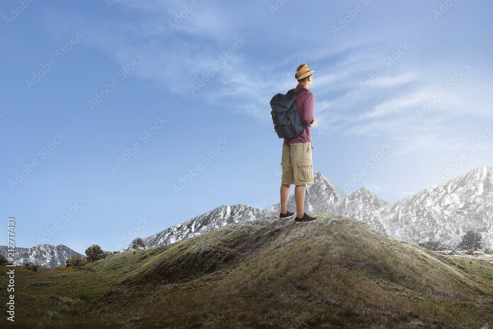 Rear view of asian traveler standing and enjoying view Rear view of asian traveler standing and enjoying view