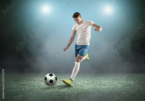 Soccer player on a football field in dynamic action at summer day © Andrii IURLOV