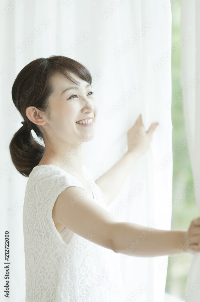 カーテンを開ける女性 カーテンを開ける女性