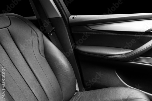 Modern Luxury car inside. Interior of prestige modern car. Comfortable leather Black seats. Black  perforated leather cockpit with isolated Black background. Modern car interior details. Car detailing © Aleksei