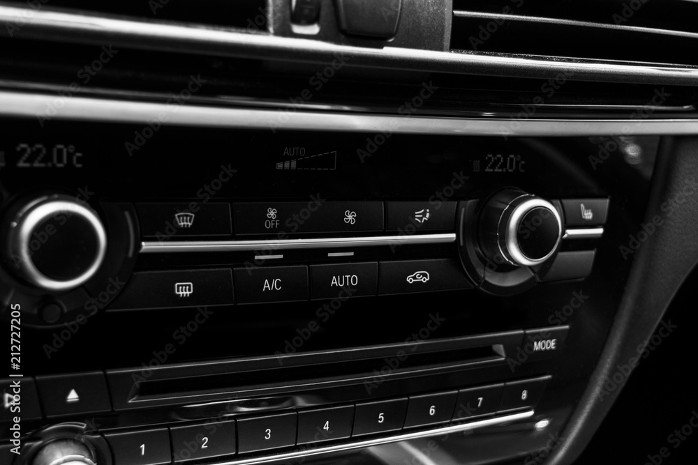 Air conditioning button inside a car. Climate control AC unit in the new car. Modern car interior details. Car detailing. Black perforated leather interior. Black and white