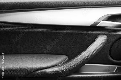 Door handle with Power window control buttons of a luxury passenger car. Black leather interior of the luxury modern car. Modern car interior details. Car detailing © Aleksei
