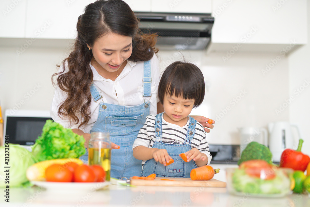 Mother with her daughter preparing lunch in the kitchen and enjoying together. Mother with her daughter preparing lunch in the kitchen and enjoying together.