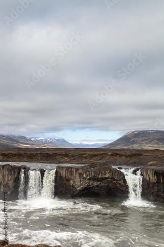 Water of the Godafoss Waterfall - beautiful part of stony rocky desert landscape of Iceland. Toned.