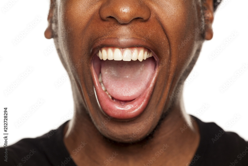 Obraz premium Otwarte usta zbliżenie młody czarny facet Afroamerykanin na białym tle