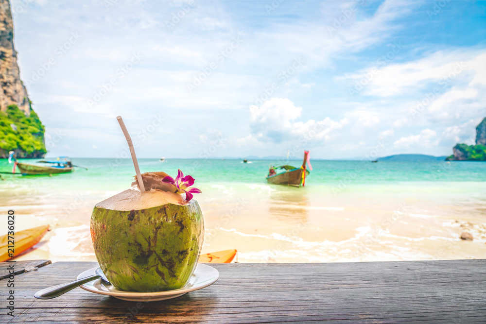 Coconut fruit drink at beautiful Tropical Beach blue ocean background with Traveler items vacation travel accessories for holiday or long weekend a guide choice idea for planning travel Coconut fruit drink at beautiful Tropical Beach blue ocean background with Traveler items vacation travel accessories for holiday or long weekend a guide choice idea for planning travel