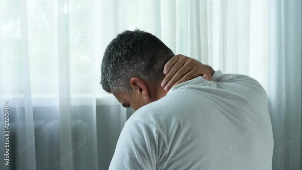 Adult man suffering sharp neck pain, massaging muscle spasm, health problem Adult man suffering sharp neck pain, massaging muscle spasm, health problem