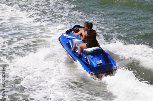 Couple riding tandem on a blue jet ski on the Florida Intra-Coastal Waterway. © Wimbledon