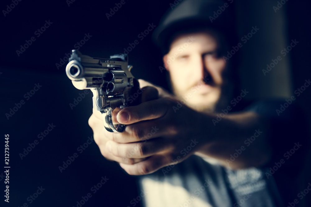Man holding a gun with black background Man holding a gun with black background