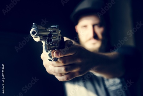 Man holding a gun with black background