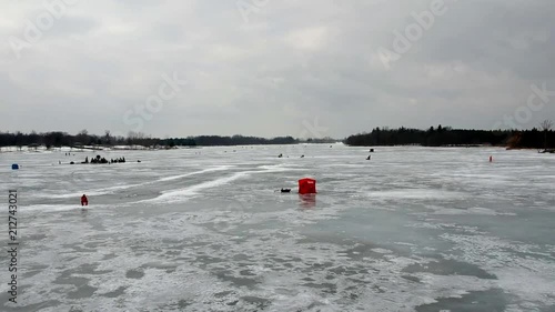 Drone footage of a frozen lake and a person fishing. photo