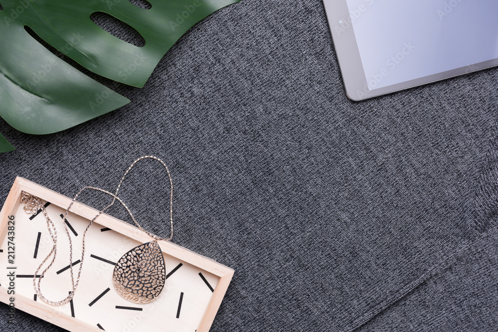 Female fashion concept. Simple design of accessory and pad on dark color textile background. Female fashion concept. Simple design of accessory and pad on dark color textile background.
