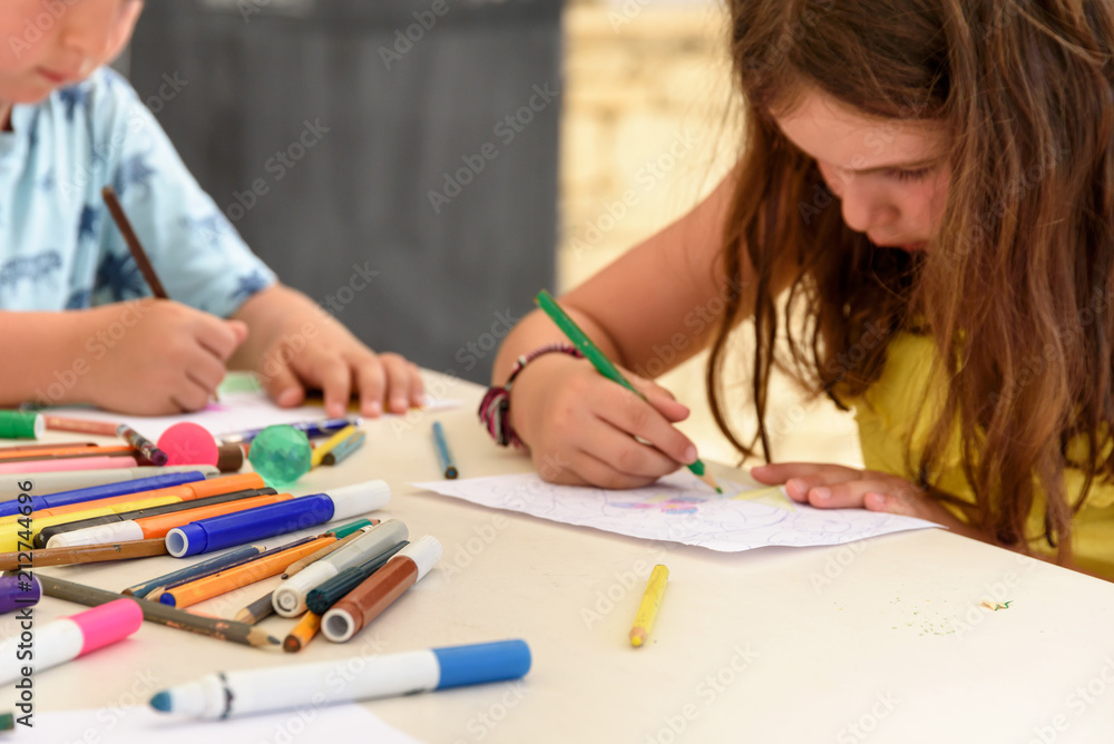 Cute little kids drawing and painting with colorful markers pens at kindergarten. Creative activities at summer playschool Cute little kids drawing and painting with colorful markers pens at kindergarten. Creative activities at summer playschool