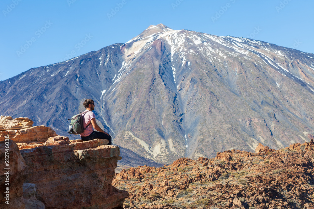 Fototapeta premium Traveler man on the edge of rock enjoy volcano El Teide