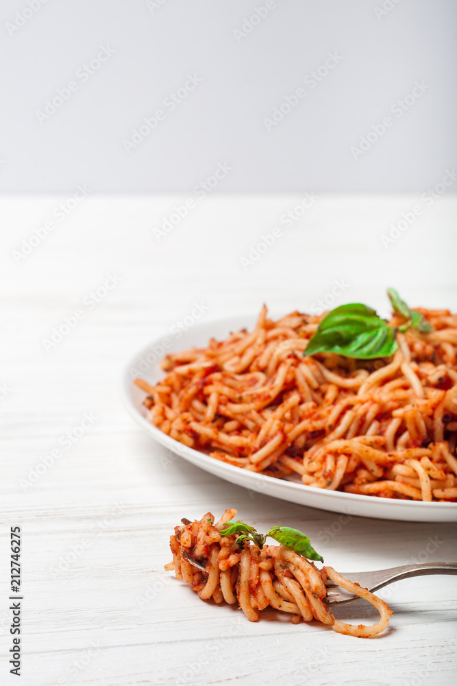 Italian spaghetti with a bolognese tomato meat sauce and basil in a plate. Copy space. Italian food concept. Italian spaghetti with a bolognese tomato meat sauce and basil in a plate. Copy space. Italian food concept.