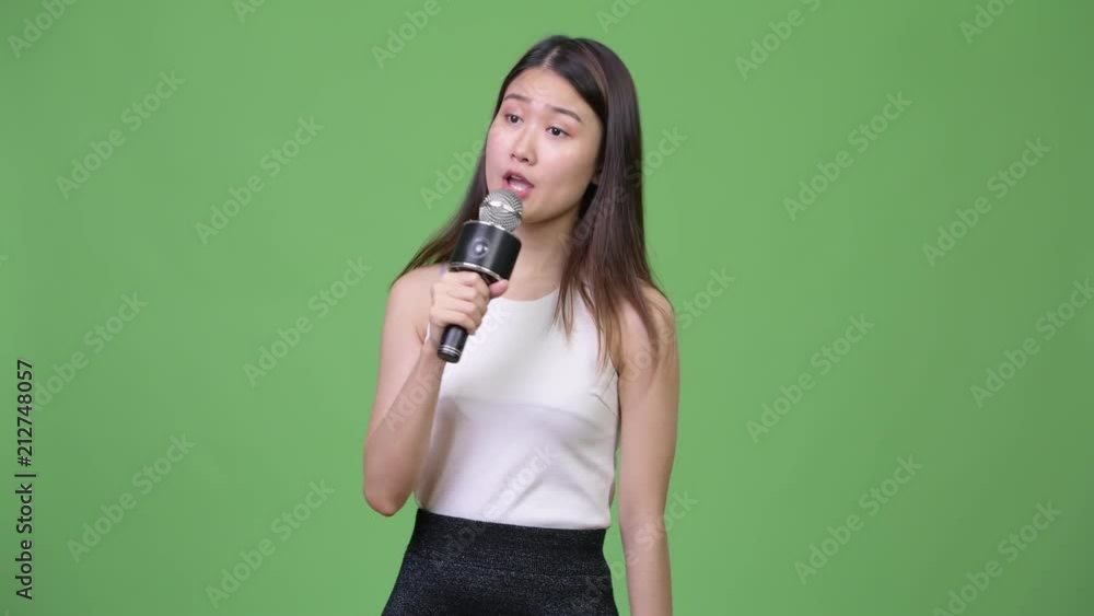 Young beautiful Asian businesswoman singing Young beautiful Asian businesswoman singing
