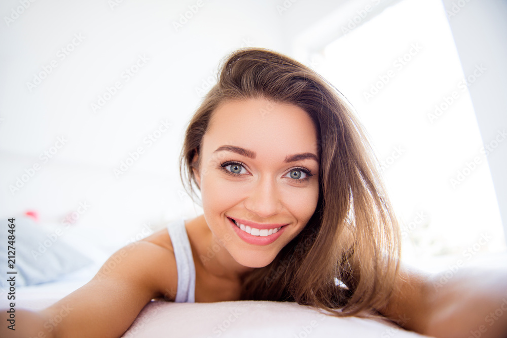 Self portrait of pretty charming girl with beaming smile lying on bed having online meeting day health healthy good life attractive face concept Self portrait of pretty charming girl with beaming smile lying on bed having online meeting day health healthy good life attractive face concept