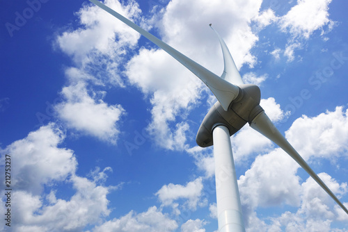 Wind turbine seen from below in a beautiful summer day with blue sky 