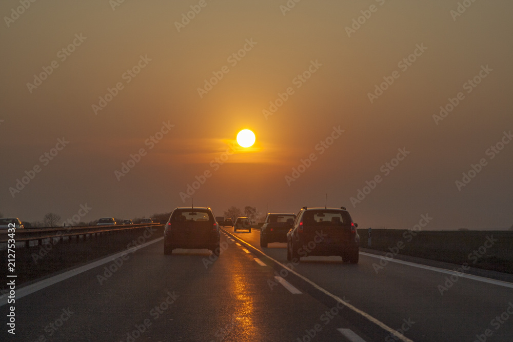 traffic at  european highway with cars and romantic sunset in front