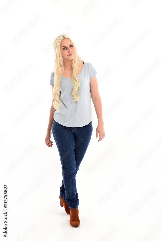 full length portrait of blonde girl wearing blue shirt and jeans, standing pose isolated on white studio background. full length portrait of blonde girl wearing blue shirt and jeans, standing pose isolated on white studio background.