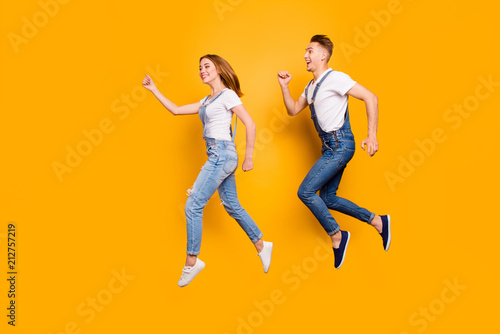 Teen age two cheerful joyful people sale discount shopping concept. Profile full length size photo portrait of funky funny rejoicing beautiful spouses hurrying up isolated background copy-space