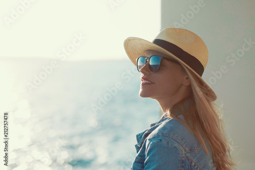 Blonde traveler woman portrait in hat on cruise ship, looking away