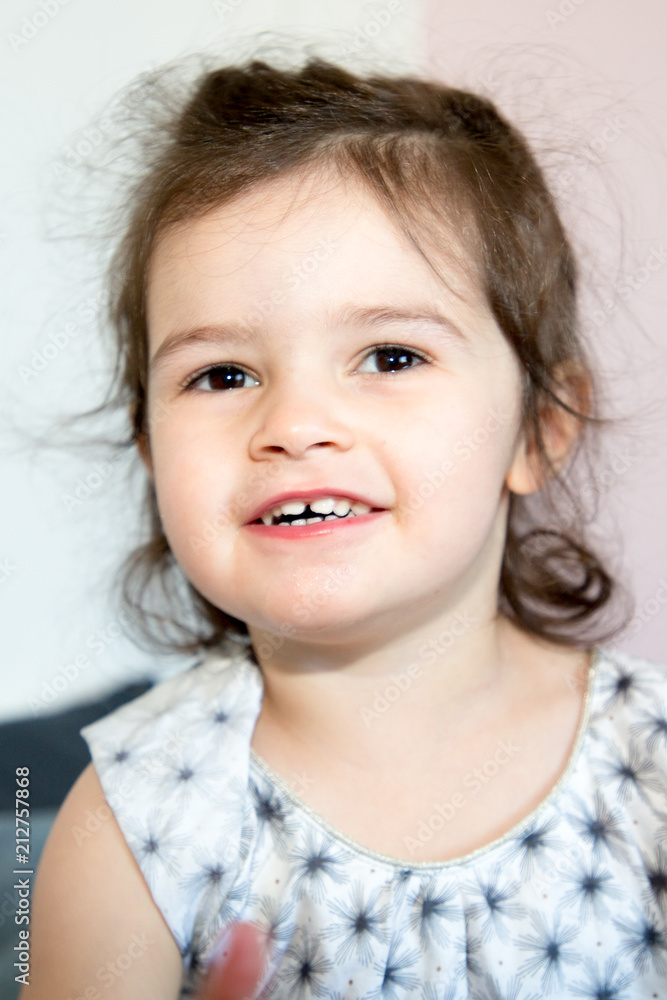 Portrait of a charming little girl smiling at camera in bed room Portrait of a charming little girl smiling at camera in bed room