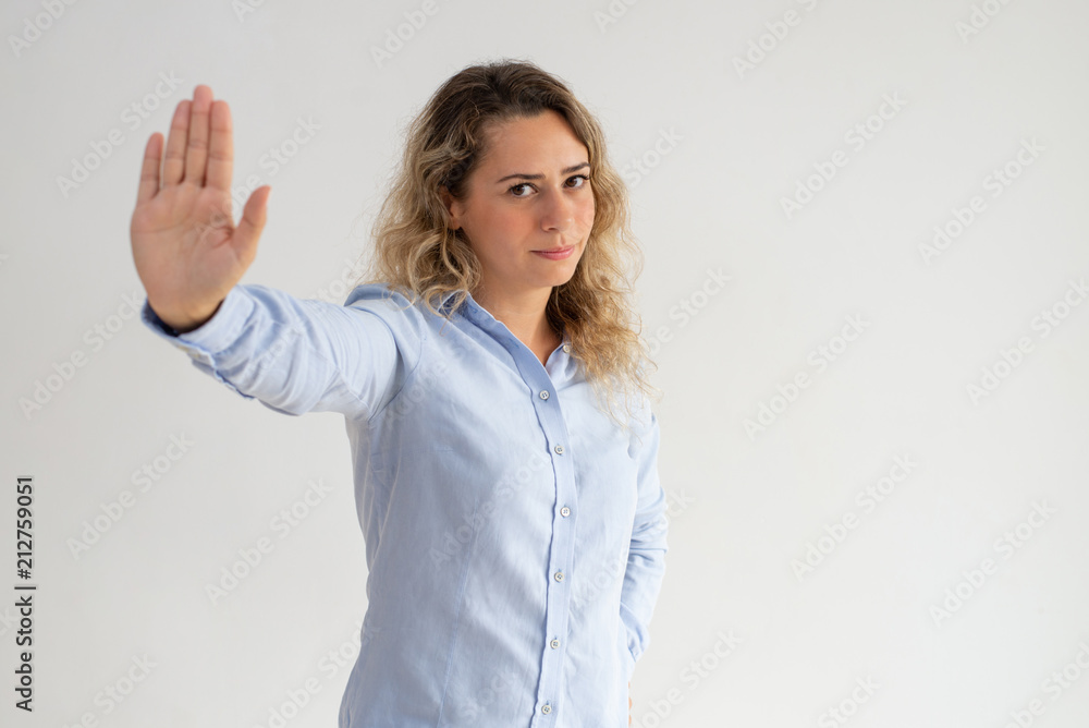 Serious displeased woman making stop gesture. Disappointed lady rejecting and gesturing while looking at camera. Cancelation concept Serious displeased woman making stop gesture. Disappointed lady rejecting and gesturing while looking at camera. Cancelation concept