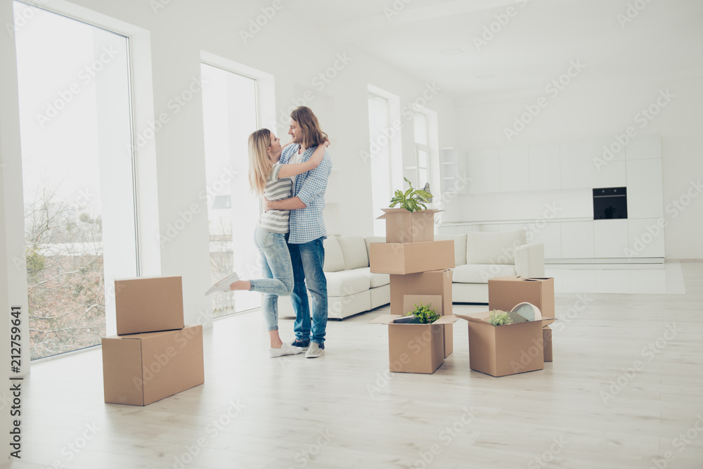 It's a new period in our life! Lovely charming cheerful lovers kissing in recently bought property. Pretty beautiful lady hugging her masculine man's neck wearing casual jeans checkered shirt clothes It's a new period in our life! Lovely charming cheerful lovers kissing in recently bought property. Pretty beautiful lady hugging her masculine man's neck wearing casual jeans checkered shirt clothes
