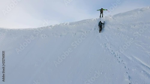 Stunning aerial drone footage of two hikers on a mountain ridge (arete) near the summit of Aletschhorn mountain in the Bernese Alps, Switzerland. Ebnefluh and Gletscherhorn mountains in background. photo