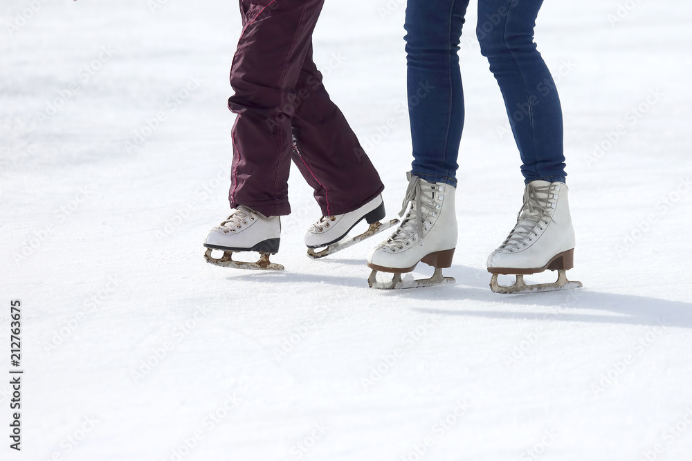 child and adult skates at the ice rink. child and adult skates at the ice rink.