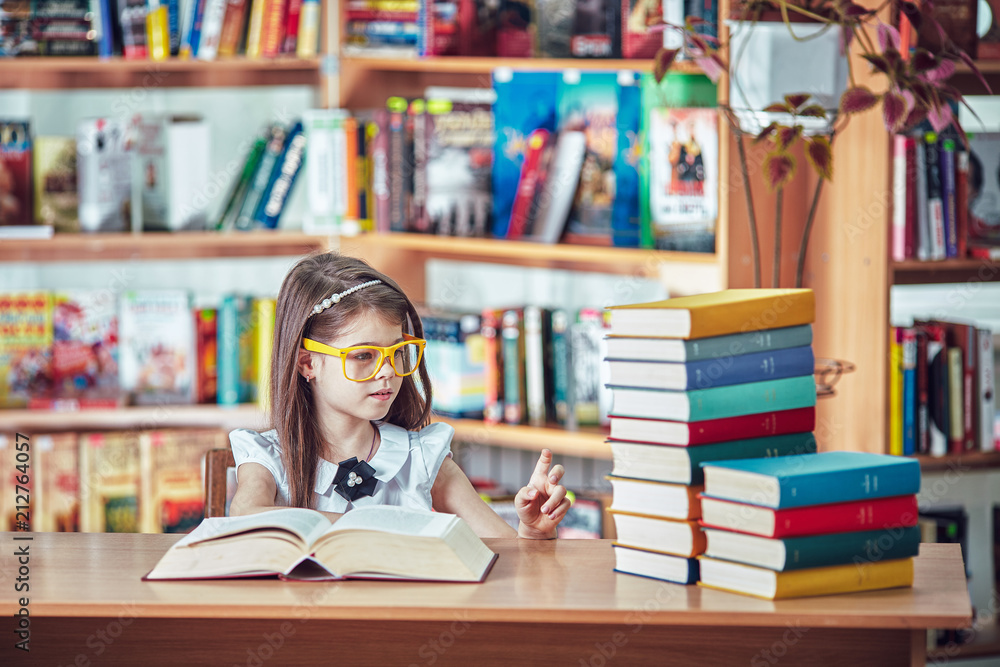 Back to school and happy time! Cute industrious child is sitting at a desk indoors. Back to school and happy time! Cute industrious child is sitting at a desk indoors.