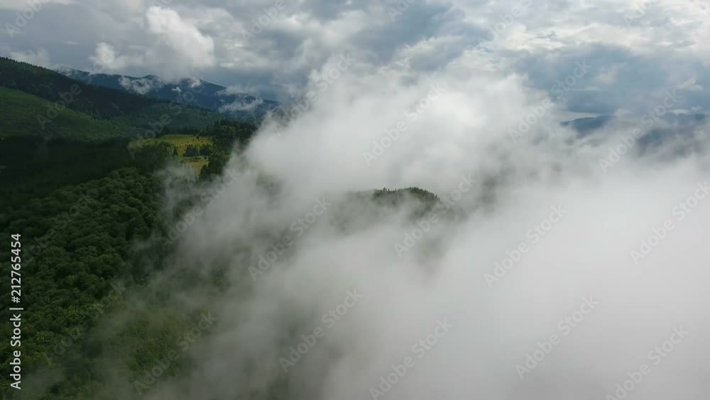 Aerial shot of a Carpathian mountain covered with a misty cloud in summer Aerial shot of a Carpathian mountain covered with a misty cloud in summer