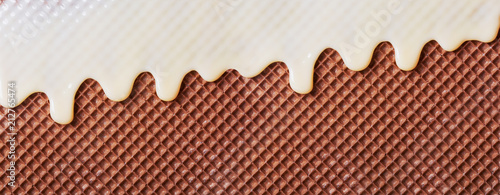 White hot chocolate on the wafer. Waffle covered with condensed milk close-up. White hot chocolate spreads on the wafer.